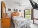 Bright bedroom with a wooden headboard, ceiling fan, and a window overlooking the outdoors at 8850 Se 156Th St, Summerfield, FL 34491