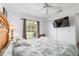 Bright bedroom featuring a window with blinds, ceiling fan, and closet, promoting relaxation at 8850 Se 156Th St, Summerfield, FL 34491