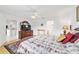 Spacious primary bedroom featuring wood floors, a large dresser, an ensuite bath and access to kitchen at 8850 Se 156Th St, Summerfield, FL 34491