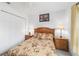 Cozy bedroom features neutral-colored walls, wooden furniture, and a large window at 8850 Se 156Th St, Summerfield, FL 34491