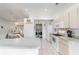 Bright kitchen featuring white appliances and cabinets, island seating, and a laundry closet at 8850 Se 156Th St, Summerfield, FL 34491
