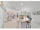 Open-concept kitchen with island seating, white cabinetry, and views to the dining area at 8850 Se 156Th St, Summerfield, FL 34491