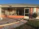 Inviting screened-in front porch with comfortable seating on a charming tiled patio at 8850 Se 156Th St, Summerfield, FL 34491