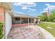 Relaxing screened patio with red brick pavers, seating and views of the landscaped backyard at 8850 Se 156Th St, Summerfield, FL 34491
