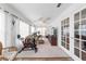 Comfortable sunroom with exercise equipment, ceiling fan, white walls and plush carpeting at 8850 Se 156Th St, Summerfield, FL 34491