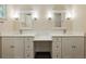 Elegant bathroom featuring double sinks, white cabinets, and modern lighting fixtures at 9269 Silver Lake Dr, Leesburg, FL 34788
