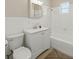 White tiled bathroom with shower/tub combo, vanity and sink, medicine cabinet, toilet and neutral rug at 9269 Silver Lake Dr, Leesburg, FL 34788