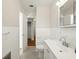 Clean bathroom with white tiling, vanity with sink, mirror, and view into hallway and closet at 9269 Silver Lake Dr, Leesburg, FL 34788