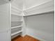 Organized walk-in closet with white shelving and wooden floors for ample storage at 9269 Silver Lake Dr, Leesburg, FL 34788