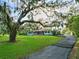 Well-maintained home with a spacious front yard, mature trees, and a winding driveway leading to the residence at 9269 Silver Lake Dr, Leesburg, FL 34788
