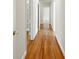 Bright hallway featuring hardwood flooring and white walls with an open door for closet access at 9269 Silver Lake Dr, Leesburg, FL 34788