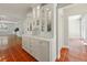 Elegant kitchen with white cabinetry, terracotta tile flooring, and glass-front display cabinets at 9269 Silver Lake Dr, Leesburg, FL 34788