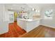 Stylish kitchen features an island, terracotta floors, modern appliances, and bright pendant lighting at 9269 Silver Lake Dr, Leesburg, FL 34788
