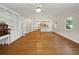 Inviting living room boasts gleaming hardwood floors and built-in shelves, flowing to the bright white kitchen at 9269 Silver Lake Dr, Leesburg, FL 34788