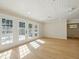 Bright living room with wood-look flooring, paneled ceiling, and natural light from french doors at 9269 Silver Lake Dr, Leesburg, FL 34788