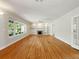 Open-concept living room with hardwood floors, fireplace, and large window views at 9269 Silver Lake Dr, Leesburg, FL 34788