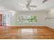 Inviting living room featuring hardwood floors, large windows offering picturesque views, and a cozy fireplace at 9269 Silver Lake Dr, Leesburg, FL 34788