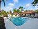Gorgeous pool surrounded by a patio, tropical landscaping, and a white fence at 9269 Silver Lake Dr, Leesburg, FL 34788