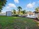 Spacious yard with a storage shed and palms creates a serene and private retreat at 9269 Silver Lake Dr, Leesburg, FL 34788