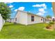 Well-maintained backyard with green lawn, lush landscaping, and a view of the home's exterior at 992 Davit Pl, The Villages, FL 32162