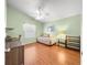 Cozy bedroom with natural light, wooden floors, a ceiling fan, and a comfortable daybed at 992 Davit Pl, The Villages, FL 32162