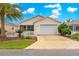 Charming single-story home with a well-manicured lawn, beautiful landscaping, and a white picket fence at 992 Davit Pl, The Villages, FL 32162