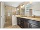 Bathroom with a double sink vanity, granite countertops, and a tiled shower with glass door at 10046 Ketch Kay Ln, Oxford, FL 34484