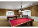 Elegant game room featuring two billiard tables, stylish lighting, and decorative wallpaper at 10046 Ketch Kay Ln, Oxford, FL 34484