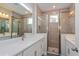 Bathroom showcasing double vanity with white countertops and large glass-enclosed shower at 10302 Pearson Ave, Orlando, FL 32827