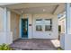 Inviting front porch with brick flooring, modern blue door, and bright natural lighting at 10302 Pearson Ave, Orlando, FL 32827