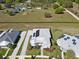 An aerial view of a house with solar panels and other community homes and amenities in the distance at 1042 Sugarloaf Key Loop, Lady Lake, FL 32159