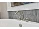 Close up of tub faucet with stylish handles, set against a modern white tub and tiled wall at 1042 Sugarloaf Key Loop, Lady Lake, FL 32159