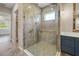 Bathroom featuring a glass enclosed shower with a rainfall shower head, designer tile, and adjacent vanity at 1042 Sugarloaf Key Loop, Lady Lake, FL 32159