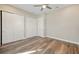 Bedroom features modern ceiling fan, wood-look floors and three closets with sliding doors at 1042 Sugarloaf Key Loop, Lady Lake, FL 32159