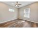 Bright bedroom features modern ceiling fan, wood-look floors and two windows at 1042 Sugarloaf Key Loop, Lady Lake, FL 32159