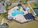 Aerial view of a community pool with lounge chairs, tables, shade structures and a tennis court at 1042 Sugarloaf Key Loop, Lady Lake, FL 32159