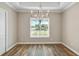 Dining room with an elegant chandelier, neutral walls, and plank flooring at 1042 Sugarloaf Key Loop, Lady Lake, FL 32159