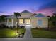 Charming single-story home with a welcoming porch and beautifully landscaped front yard at twilight at 1042 Sugarloaf Key Loop, Lady Lake, FL 32159
