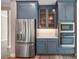 A modern kitchen with stainless steel appliances and blue cabinets, offering both style and function, plus wood-look floors at 1042 Sugarloaf Key Loop, Lady Lake, FL 32159