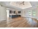 Open floorplan with wood flooring, leading to a kitchen island with pendant lighting, blue cabinets, and coffered ceiling at 1042 Sugarloaf Key Loop, Lady Lake, FL 32159