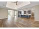 An open floor plan features wood floors, a coffered ceiling, and a kitchen with an island and stainless steel appliances at 1042 Sugarloaf Key Loop, Lady Lake, FL 32159