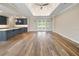Open concept living room with wood floors, view to kitchen island, coffered ceiling, and recessed lights, airy and bright at 1042 Sugarloaf Key Loop, Lady Lake, FL 32159