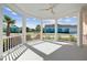 Covered porch with white railings offering serene views of the neighborhood and landscaping at 1042 Sugarloaf Key Loop, Lady Lake, FL 32159