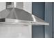 A close view of a stainless steel range hood with buttons in a kitchen, with white subway tiles in the background at 1042 Sugarloaf Key Loop, Lady Lake, FL 32159
