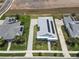 Aerial view showcasing a home with solar panels and a beautifully designed paver driveway at 1057 Sugarloaf Key Loop, Lady Lake, FL 32159