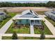Aerial view of a well-manicured property with a inviting front porch and lush landscaping at 1057 Sugarloaf Key Loop, Lady Lake, FL 32159