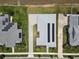 An aerial view of a single-Gathering home with solar panels, landscaped yard and a paver driveway at 1057 Sugarloaf Key Loop, Lady Lake, FL 32159