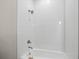 White tiled bathroom with shower over tub and modern fixtures at 1057 Sugarloaf Key Loop, Lady Lake, FL 32159