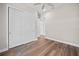 Bedroom with dark hardwood floors, closet and ceiling fan offers a modern tidy space at 1057 Sugarloaf Key Loop, Lady Lake, FL 32159
