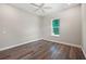 Bright bedroom with dark hardwood floors, ceiling fan, and window offers a cozy retreat at 1057 Sugarloaf Key Loop, Lady Lake, FL 32159